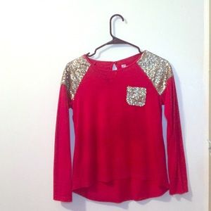 A red long sleeve with gold sequence on it.